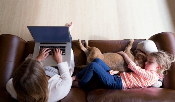 woman-using-laptop-while-daughter-and-dog-sleep-picture-id489698078